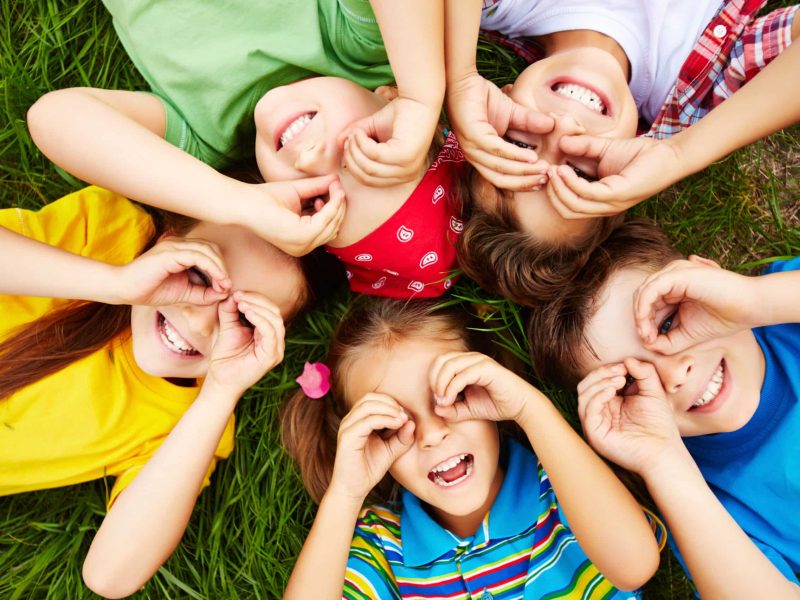 Group of cute children lying on grass